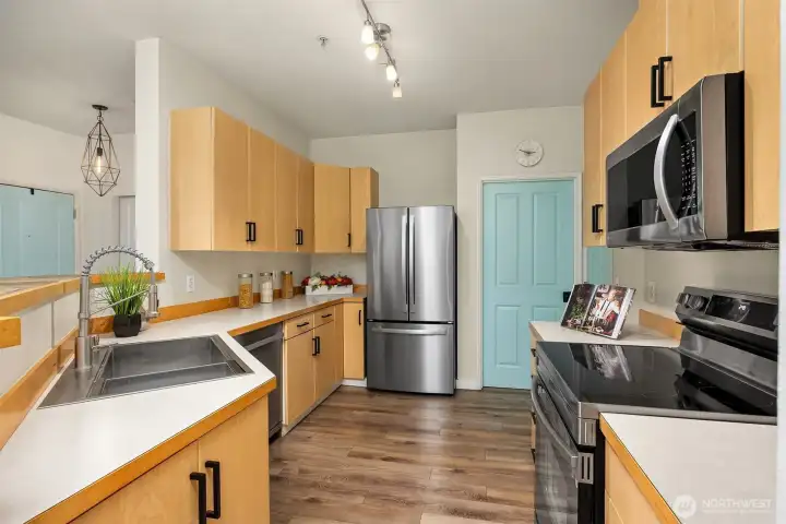 The kitchen's generous layout offers ample room to move and work, with warm cabinetry, stainless steel appliances, and a bright, airy feel that makes this space as enjoyable as it is functional.