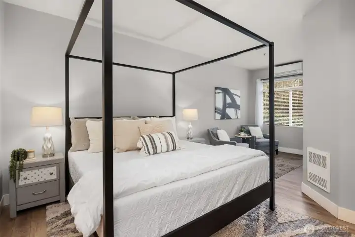 Another angle of the primary suite highlights the generous room size, warm flooring, and abundant natural light, a peaceful and private sanctuary designed for rest and relaxation.