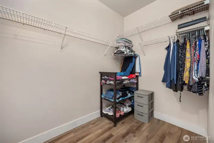 The primary suite's walk-in closet offers generous storage with built-in shelving and hanging space, a practical and well-organized feature that adds everyday convenience to this private retreat.