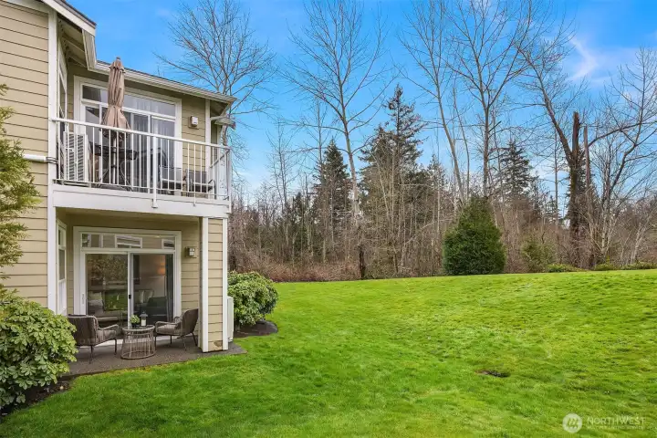 The expansive green space backing the home provides a peaceful and private natural backdrop, with the ground-floor patio offering a serene spot to relax and enjoy the beauty of the surrounding mature trees and open lawn.