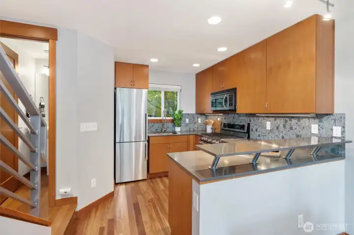 Enjoy a stylish kitchen with stone slab countertops, designer tile and gas range.