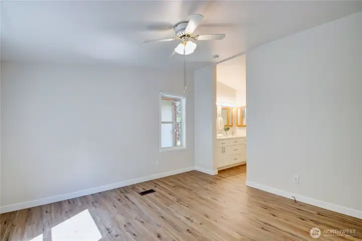 Primary with ceiling fan and entrance to bathroom. Primary with ceiling fan and entrance to bathroom.