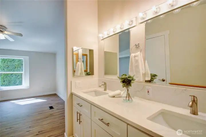 View from the primary bathroom that features a double vanity with new quartz countertops and updated cupboards. View from the primary bathroom that features a double vanity with new quartz countertops and updated cupboards.