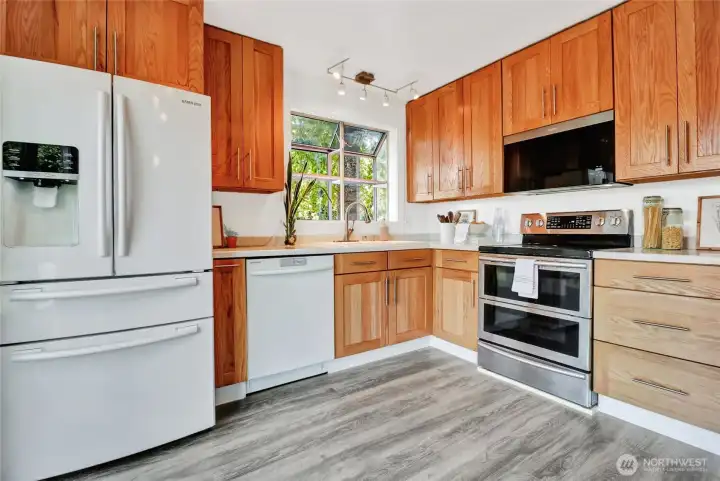 The kitchen offers a greenhouse window above the kitchen sink, double oven with ceramic cooktop, above stove microwave, refrigerator within-door water & iice dispenser, and Corian countertops.
