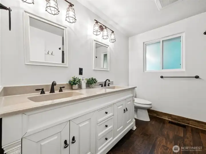Updated hall bathroom with 2 sink vanity, and spacious shower across from the vanity. Updated light fixtures and flooring.