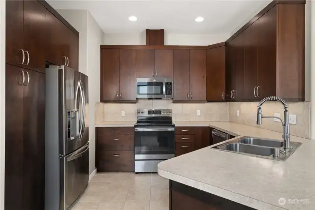 Beautifully appointed kitchen with stainless appliances, tile backsplash tile floors and lots of cabinetry for all your storage needs.  The peninsula looks out on the dining room and allows the chef to take in the panoramic views.