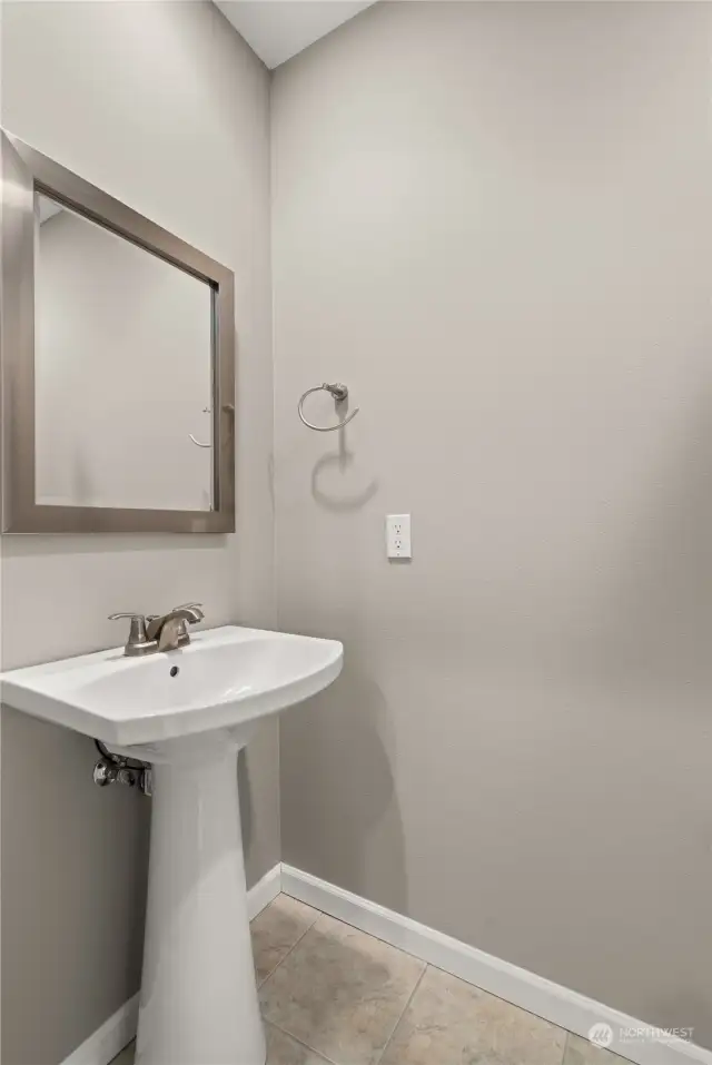 Powder room is conveniently located just off the entry way hall & is perfect for guest use.