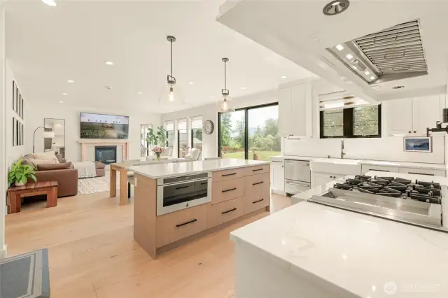Custom range hood provides excellent ventilation. The space behind the POV is the egress/ingress to the garage with additional cabinet space and a sitting area.