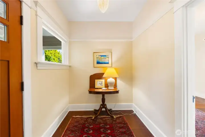 Warmly welcome guests in the Foyer.  Solid Wood Front Door, fir flooring, Original Mill work, and period lighting.  The open door on the right leads to the Office/Den.
