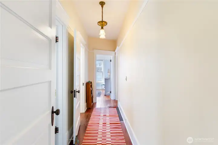 The open door at the end of the hallway is the Bedroom.  The open door on the left is the upper-level access.
