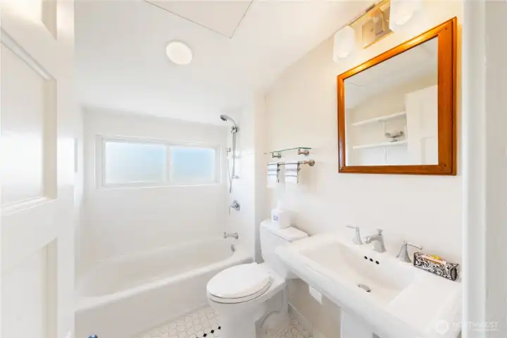 Clean, white and bright upper level Bathroom.  Overhead heating panel to keep you warmed up.