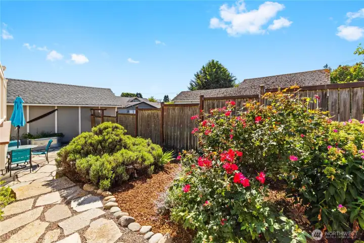 Isn't this pretty?  That's the Detached Garage with Alley Access and a Man Door on the left accessible from the back yard.  Above ground planters enhance the park-like setting.