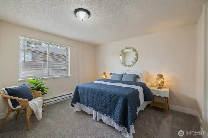 Primary bedroom with ample closet space & new carpet