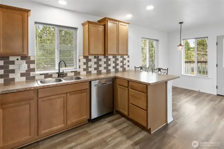 Open kitchen with eating bar and looking into the dining room.