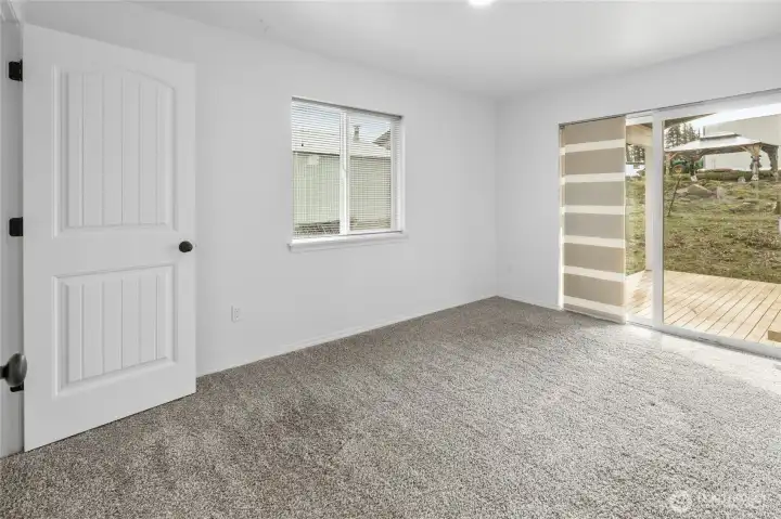 Primary bedroom with glass sliding door to the covered deck.