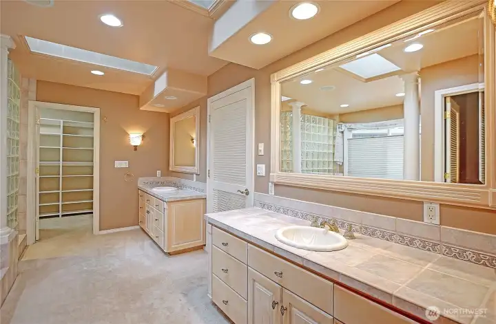 Dual vanities offer generous space and symmetry, while two walk-in closets provide ample, well organized storage.
