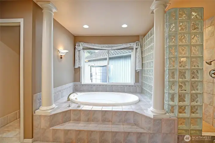 At it's center, a deep soaking tub invites quiet relaxation, complemented by a glass block shower that filters light in a soft, luminous glow.