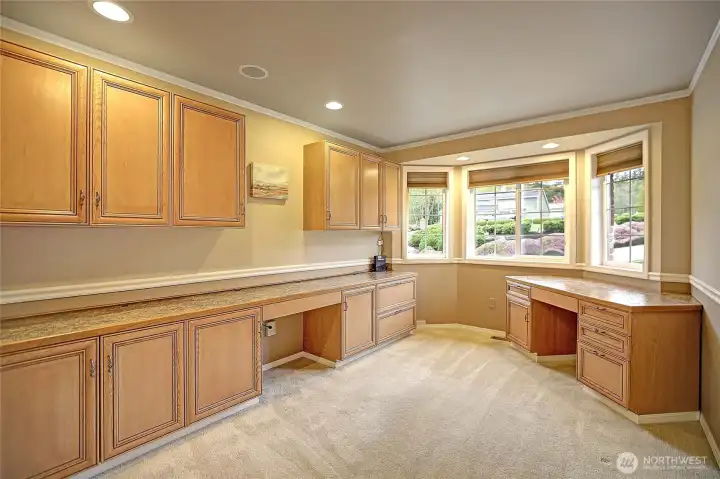 A well-designed home office features built-in cabinets for seamless storage and a spacious work area for focus and productivity. Clean lines and natural light create an inviting, organized space that's both functional and comfortable.