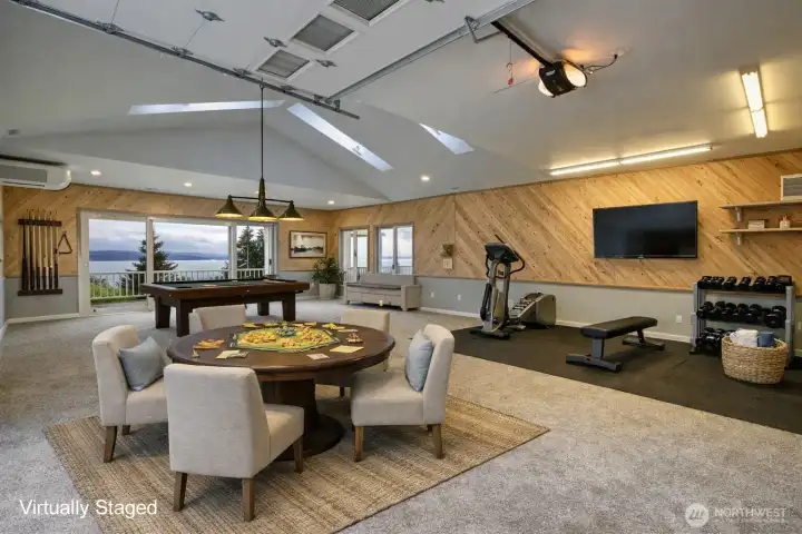 A versatile 1,665 sq ft auxiliary building steps to the main house once housed an indoor pool and spa. Today the space offers room to create, tinker, and dream without limits. The open layout can easily adapt to any passion- whether it's a workshop, art studio, fitness area, or creative retreat - while still leaving space to stay organized and uncluttered. Large windows to the view keeps the environment inspiring and functional, and generous wall space allows for storage, shelving, or displays.  The space features a full size roll up garage door, 2 sliders, single access door, and a half bathroom.  It's a place where projects can spread out, ideas can evolve, and hobbies can truly take shape - flexible enough to change with your interests and spacious enough to bring them to life.