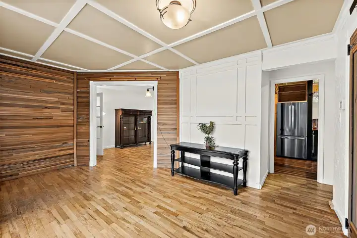 Front foyer with hardwood flooring and contrasting feature walls. Off to the right leads into the kitchen, off to the left leads to the dining area for a looped layout.