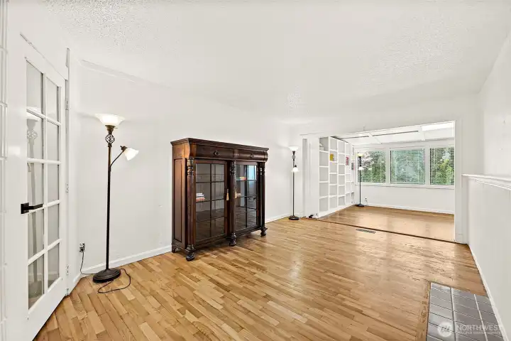 Hardwood floors, tiling from previous fireplace area. Living space that leads you to the dining and then into the kitchen at the rear of the house and out to the backyard.