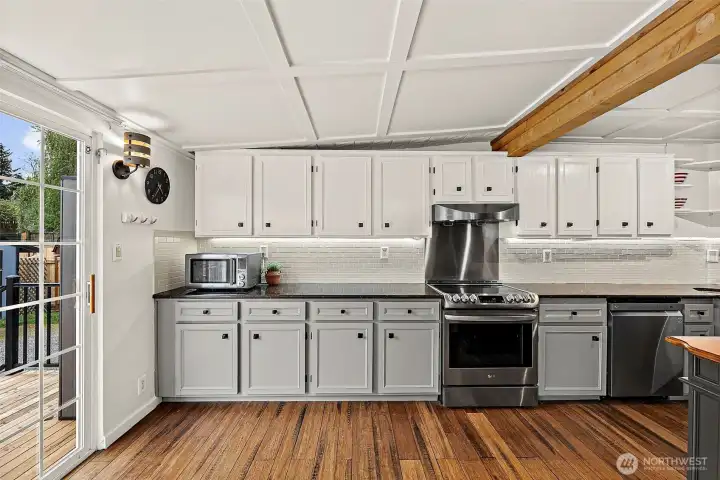 Updated kitchen located at rear of house with sliding door leading out to backyard.