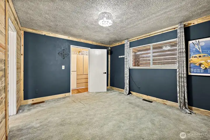 Main floor bedroom with walk-in closet and wall to wall carpeting.