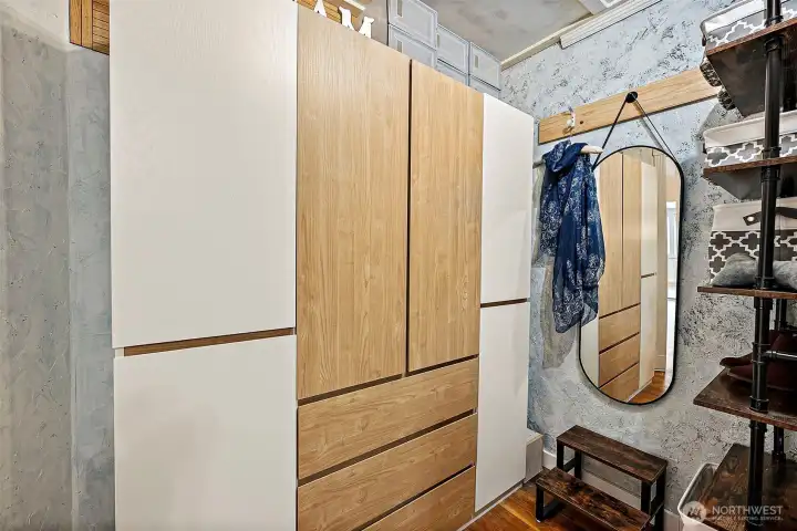 Walk-in closet off bedroom featuring hardwood floors, large attached armor and open shelving