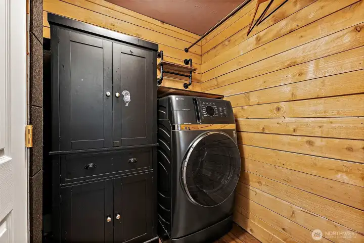 Laundry room is located on the main floor featuring a space saving all-in washer/dryer a combo unit. Iron rod goes length of room for hanging/drying needs.