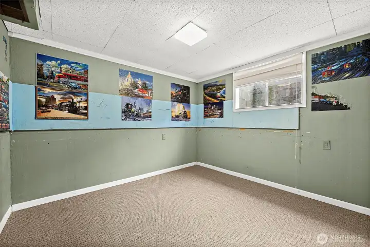 Lower level bedroom with drop ceilings and wall to wall carpeting.