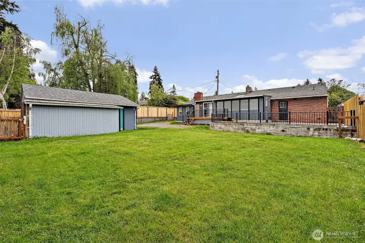 Extended fenced in patio space off the back deck with gate to the front yard on either side of the house. Sliding exterior entry doors off the kitchen/dining area at rear of house.