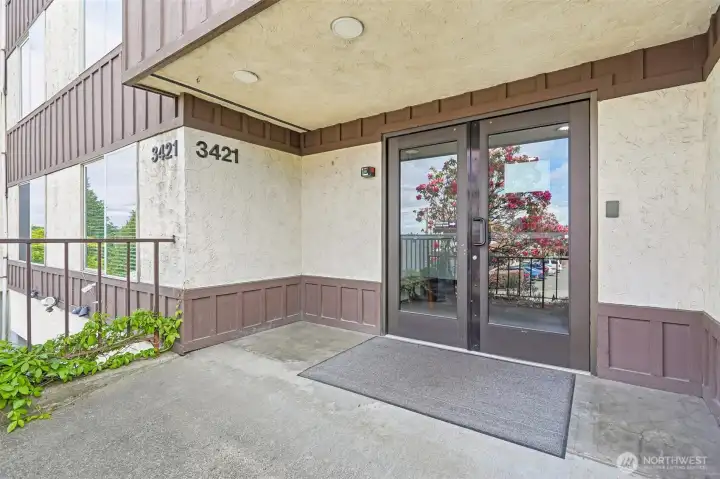 Bright sliding glass door entry to a private balcony with treetop views.