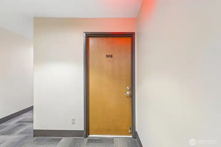 Welcoming entry foyer with a solid wood door and clean, neutral finishes.