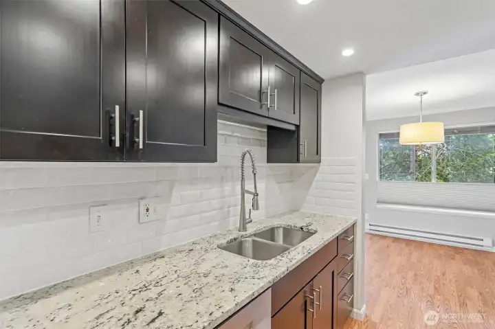 Sleek kitchen with dark cabinetry, granite countertops, and a generous prep island.