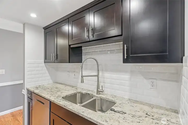 Chef-ready kitchen featuring dark cabinets, stainless sink, and designer hardware.