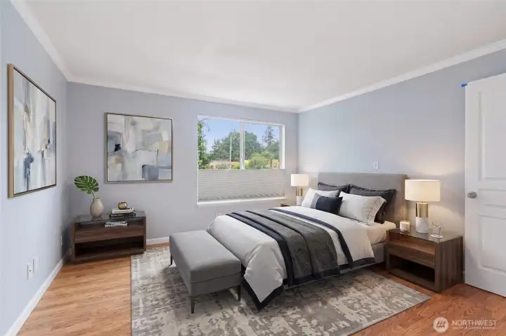 Tranquil second bedroom with soft natural light and warm hardwood floors.