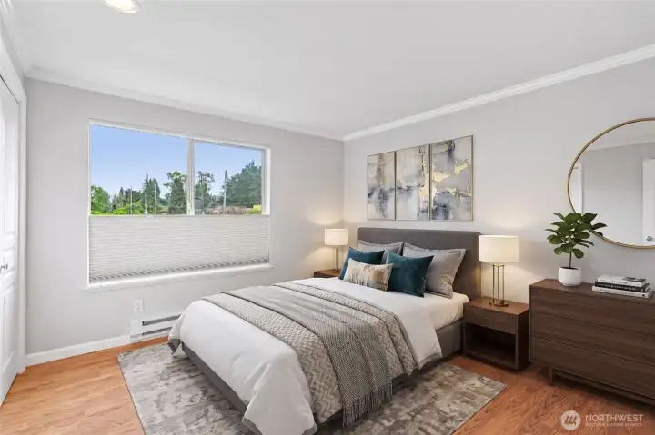 Sun-filled bedroom with a refined headboard, warm tones, and a garden view.