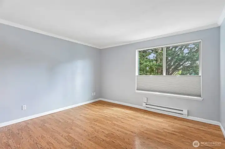 Bright room with a sunny window view and beautiful hardwood floors throughout.