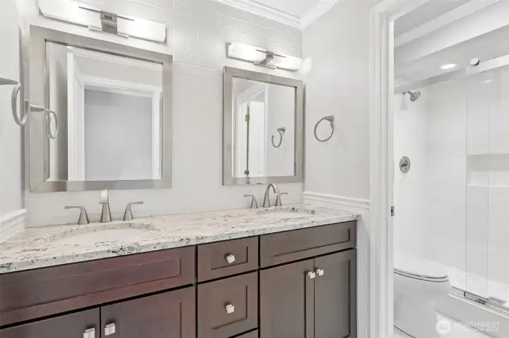Beautifully updated bathroom vanity with dark wood cabinetry and elegant fixtures.