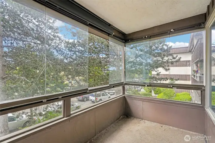Stunning enclosed sunroom with panoramic windows overlooking the treetops — your private retreat.