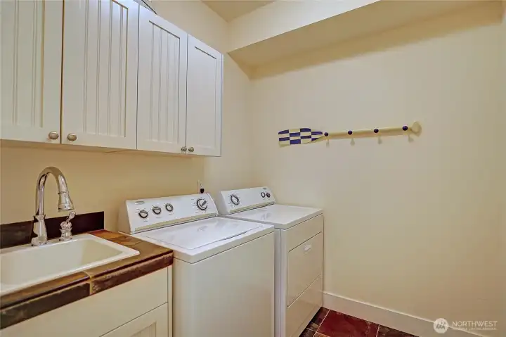 Full laundry room with sink & storage.