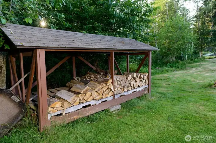 Covered firewood rack in the backyard, stacked with wood and ready for your own fire pit gatherings! Covered firewood rack in the backyard, stacked with wood and ready for your own fire pit gatherings!