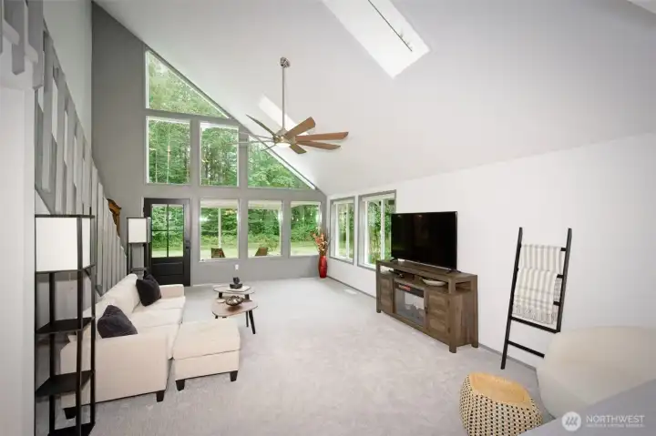 Living room with large windows and skylights for lots of natural light and access to the covered deck. Living room with large windows and skylights for lots of natural light and access to the covered deck.