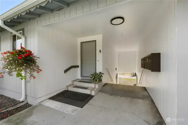 Covered entry for unit 5 and the breezeway leads to the mailboxes and laundry facility