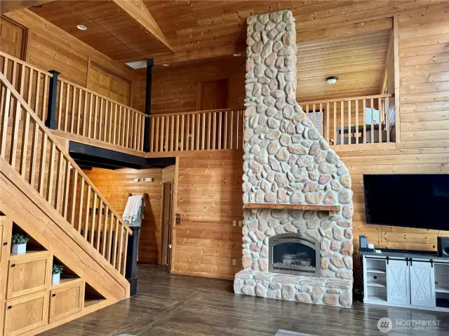 2 story local stone gas fireplace, 2nd floor landing wraps around the room. All paneling and flooring is custom designed tongue and groove
