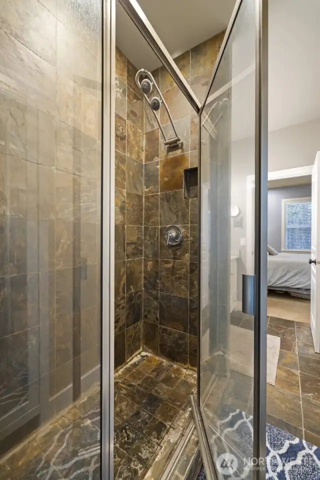 The shower is slate tile and has dual heads.