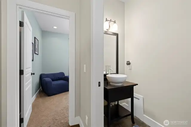 There is a powder room for guests and a den beyond that.