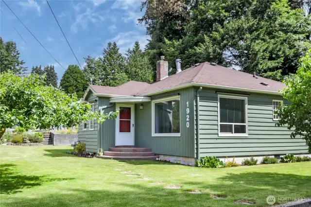 Lush apple tree and gardens add charm to this home