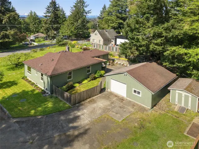 Overhead shot showing layout of home fenced back yard, patio, and garage