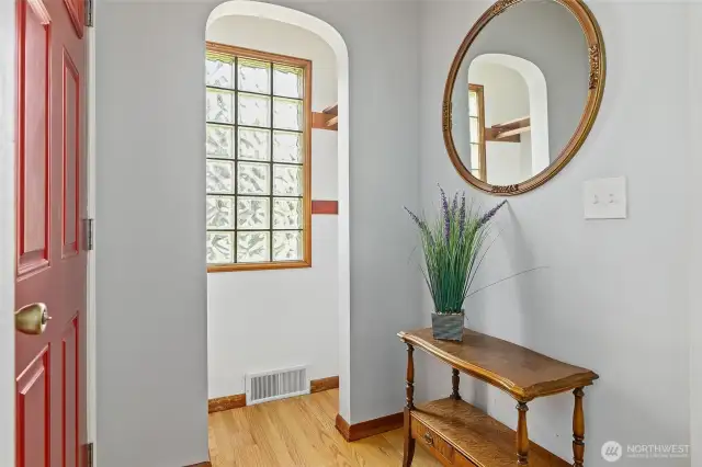 Love the hardwood floors and classic archways! Foyer into coat closet. Glass blocks for light and privacy